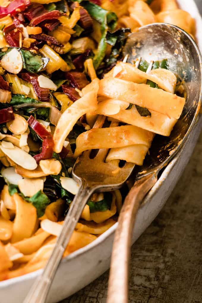 This tuscan pasta feast is a quick way to get extra veggies. Rich roasted red pepper pasta with bitter wilted Italian green and toasted almonds.