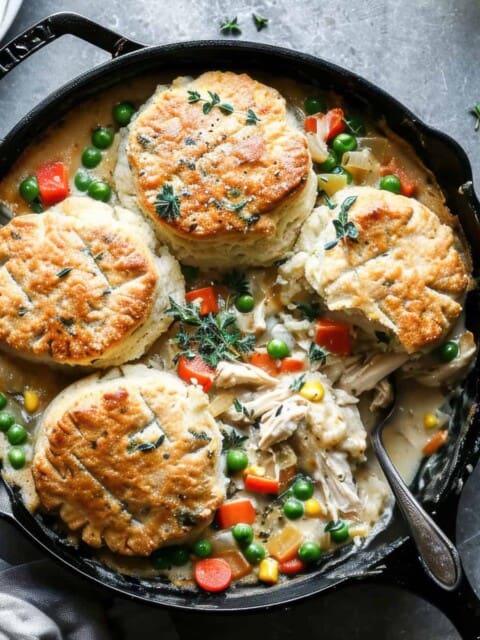 Chicken pot pie with biscuits in a skillet.