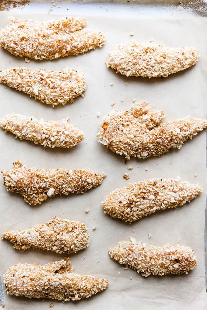 Crispy chicken tenders on a baking tray.