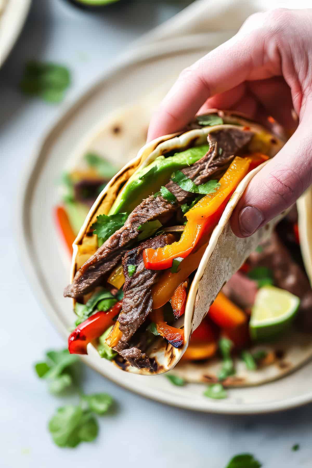 Marinated flank steak fajitas with peppers and avocado.