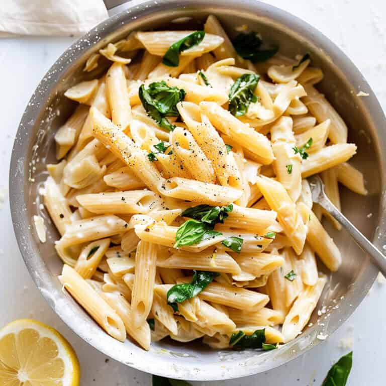 Lemon and artichoke pasta with spinach in a pan.