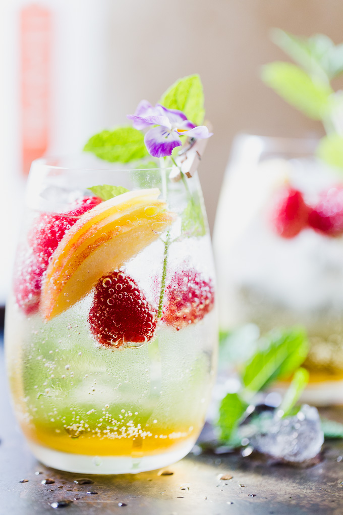 Peach sangria in a glass with raspberries