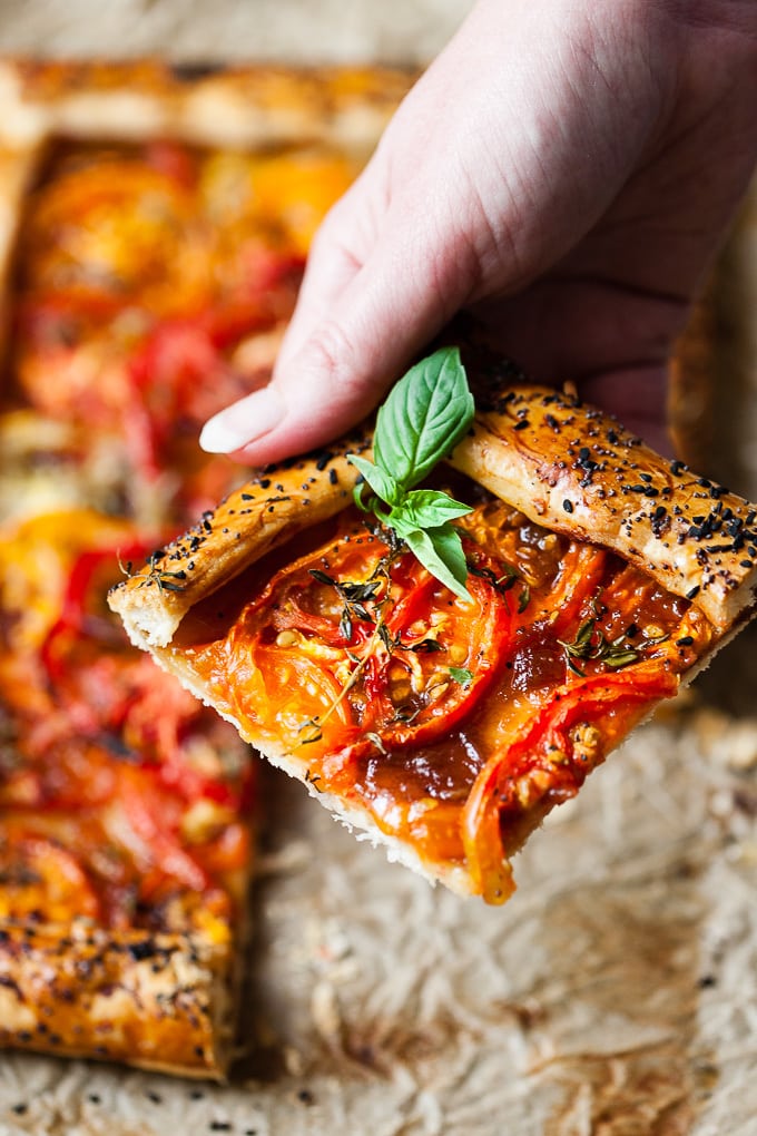 Slice of tomato tart with thyme and basil.