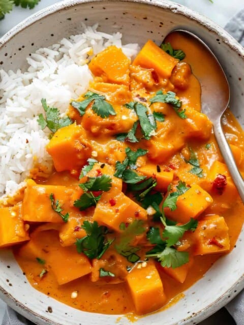 Easy vegetarian pumpkin curry with coconut milk in a white bowl.