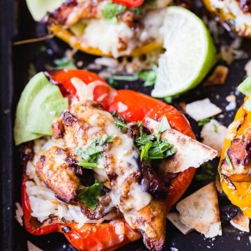 Chicken stuffed peppers on a baking tray.