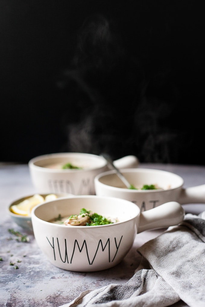 3 bowls Creamy chicken wild rice soup against a black background with steam coming off them.