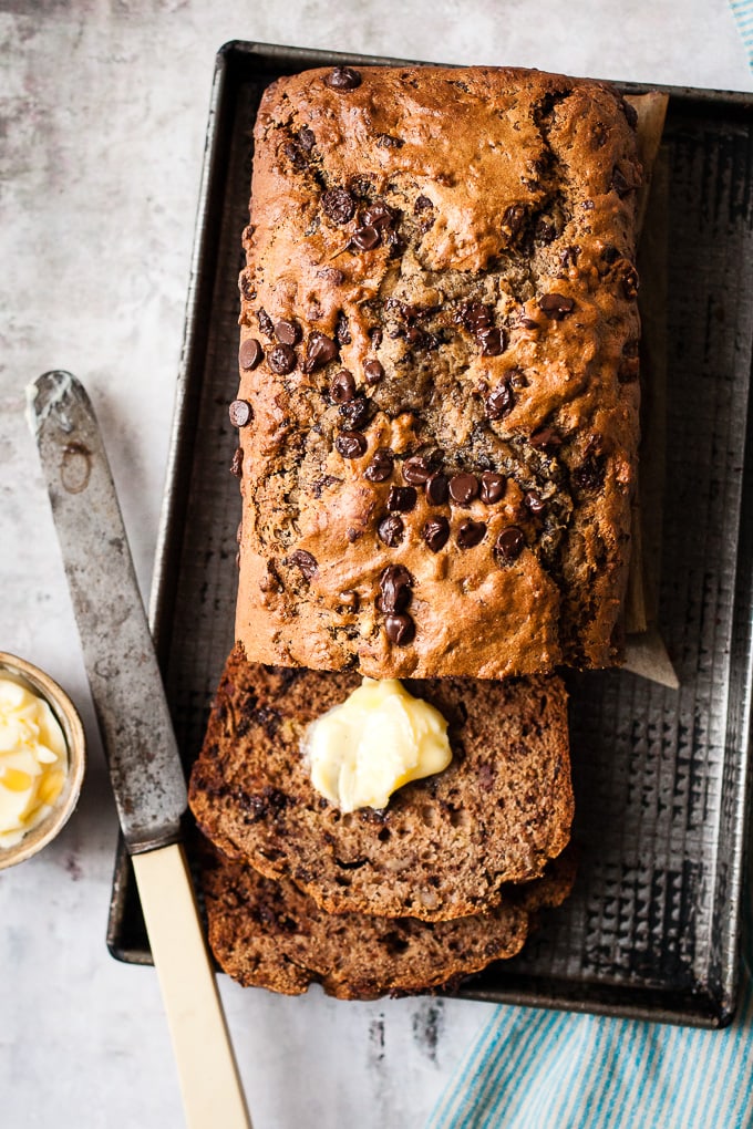 Sour Cream Chocolate chip banana bread on a baking tray with a knife.