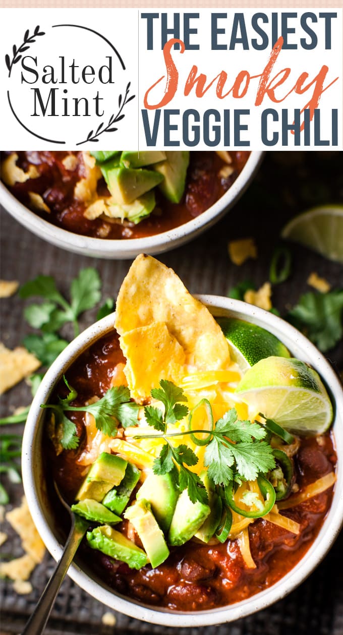 Two bowls of black bean chili with all the toppings on a wood table with text overlay.