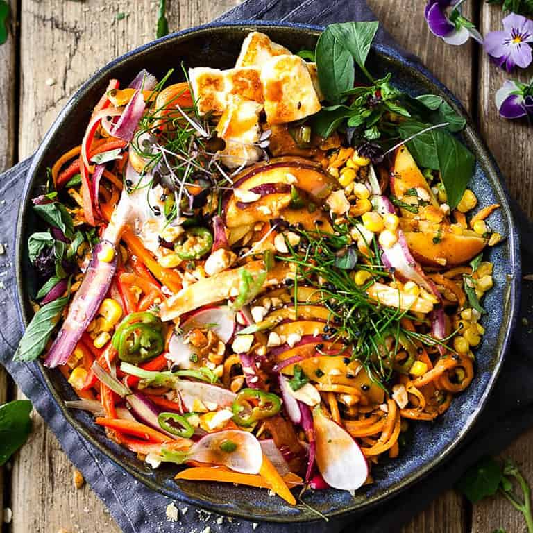 Asian noodles with tofu in a blue bowl.