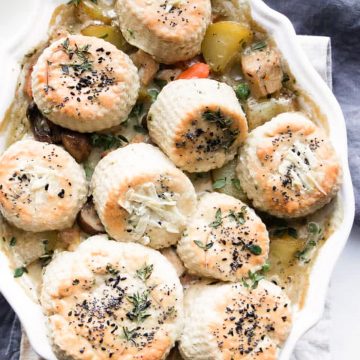 Chicken pie with biscuit topping in a white dish.