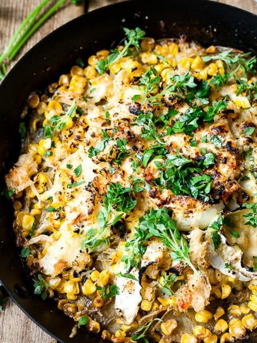 Corn and potato bake in a skillet on a table.