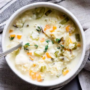 Creamy chicken soup with thyme leaves.