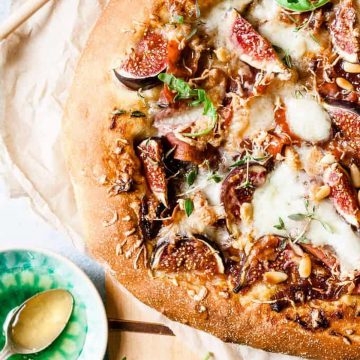 Prosciutto pizza with cheese and basil.