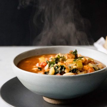 Healthy minestrone soup in a blue bowl.