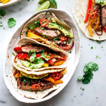 Steak fajitas with bell peppers and avocados.