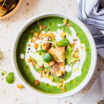 Watercress soup with croutons in a bowl.