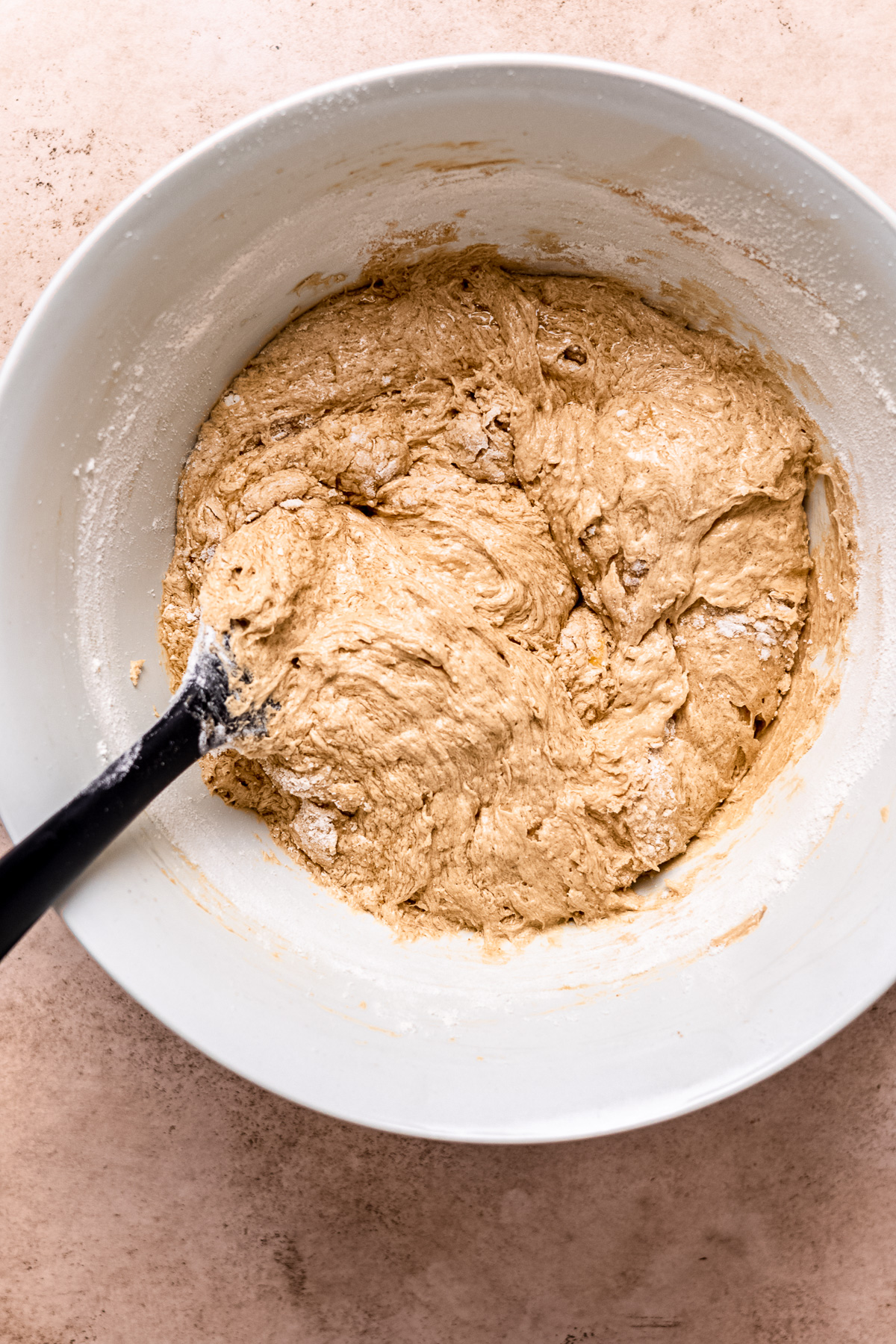 Flour is added to chocolate chip cookie dough.