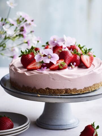 Strawberry no bake cheesecake on a cake platter.
