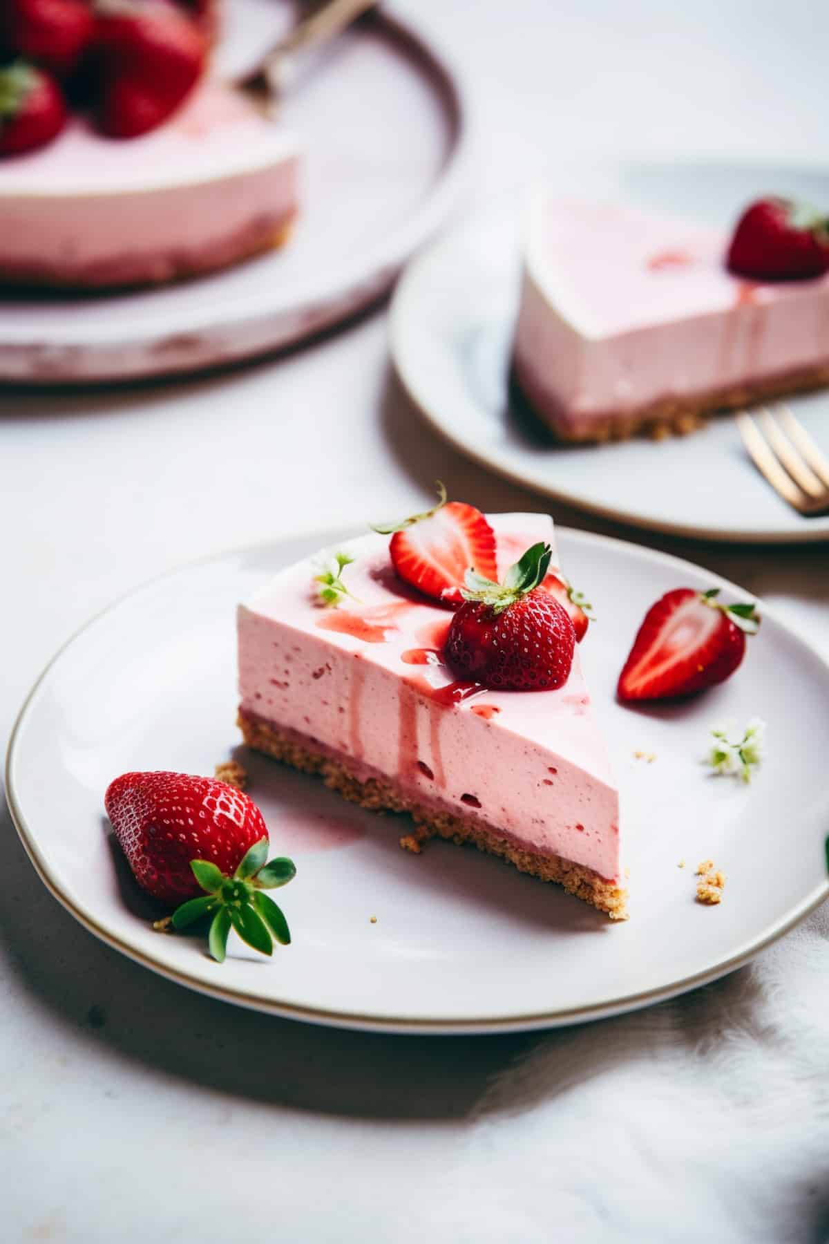 A slice of strawberry no bake cheesecake on a white plate.