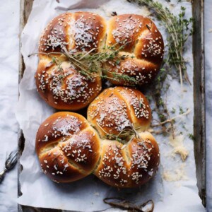 Bread rolls with seeds and herbs in a tray.