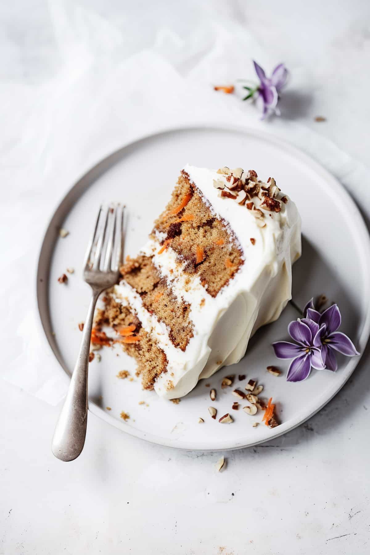 A slice of carrot cake with cream cheese frosting.