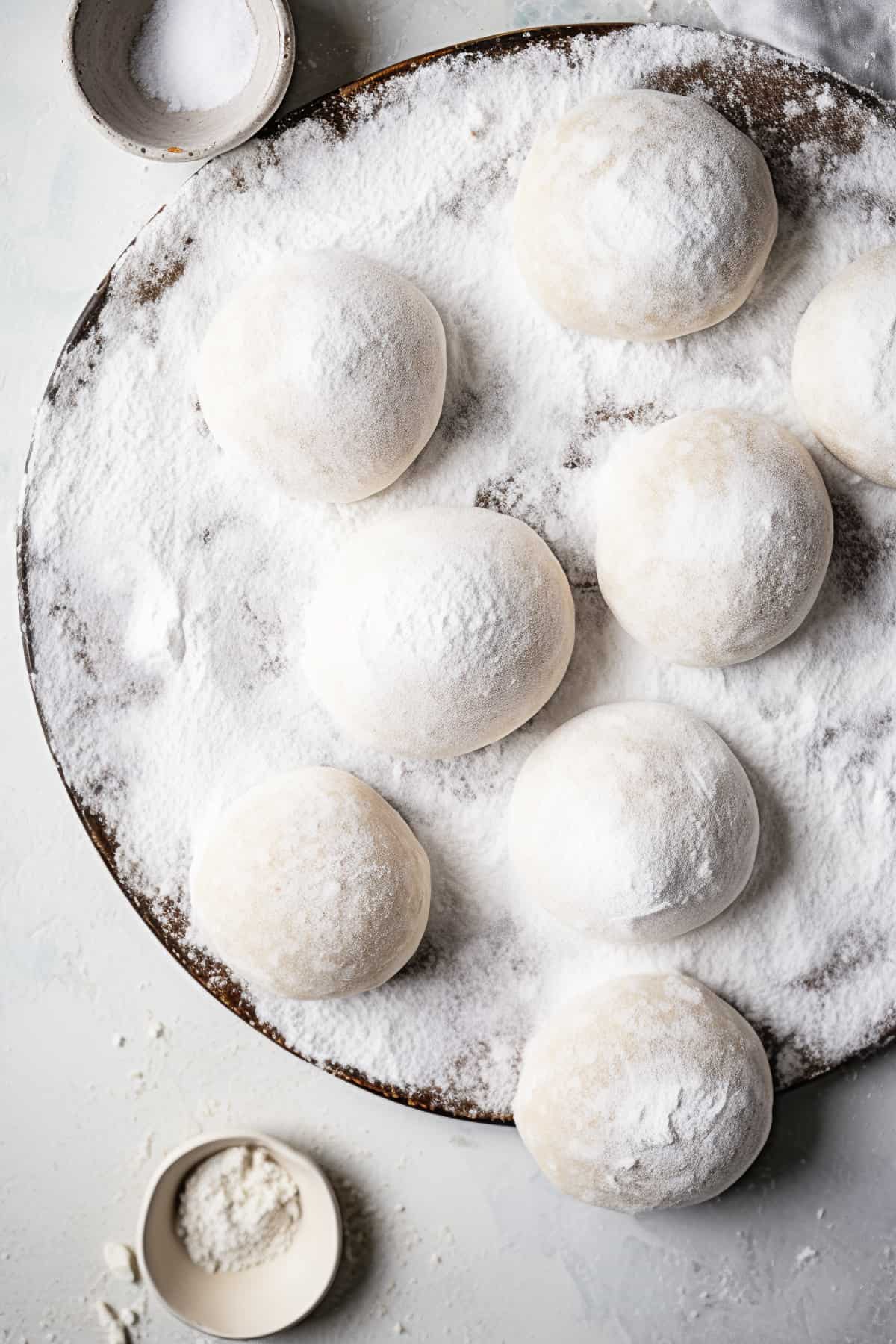 Naan bread being proved on a floured surface.