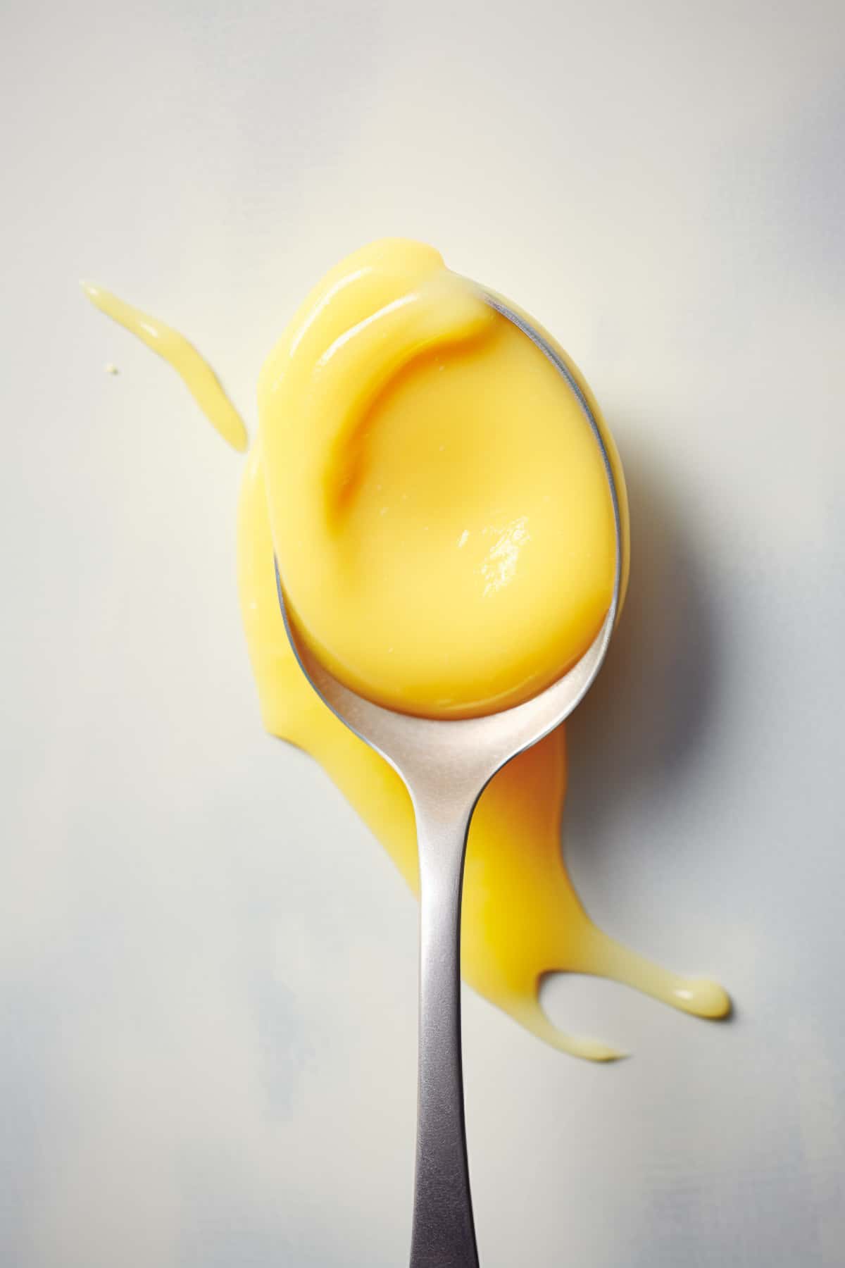 Close up of lemon curd on a spoon.