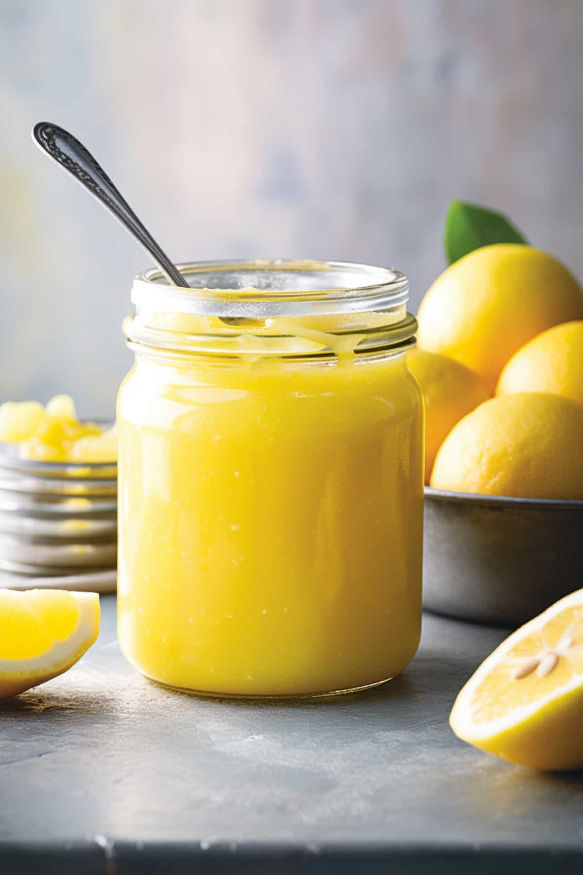 Lemon curd in a jar with a spoon.