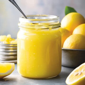 Lemon curd in a jar with a spoon.