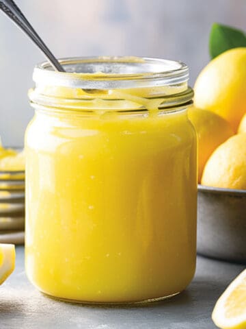 Lemon curd in a jar with a spoon.