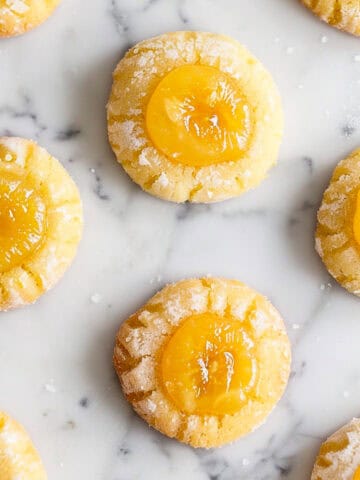 Lemon Curd Cookies on a white marble table with icing sugar.