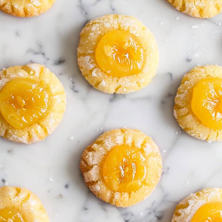 Lemon Curd Cookies on a white marble table with icing sugar.