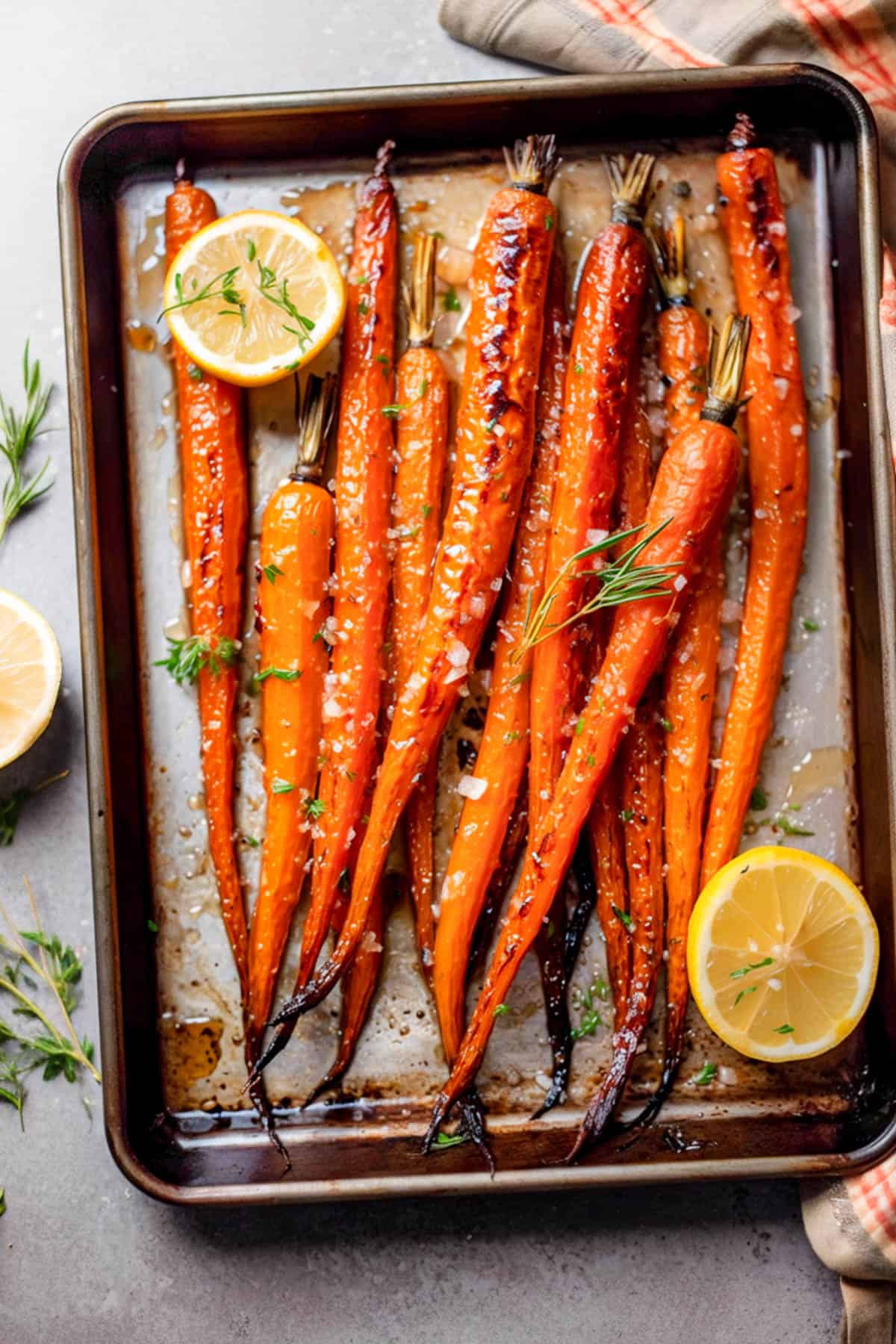 Maple-glazed carrots with lemon and sea salt on a baking tray.