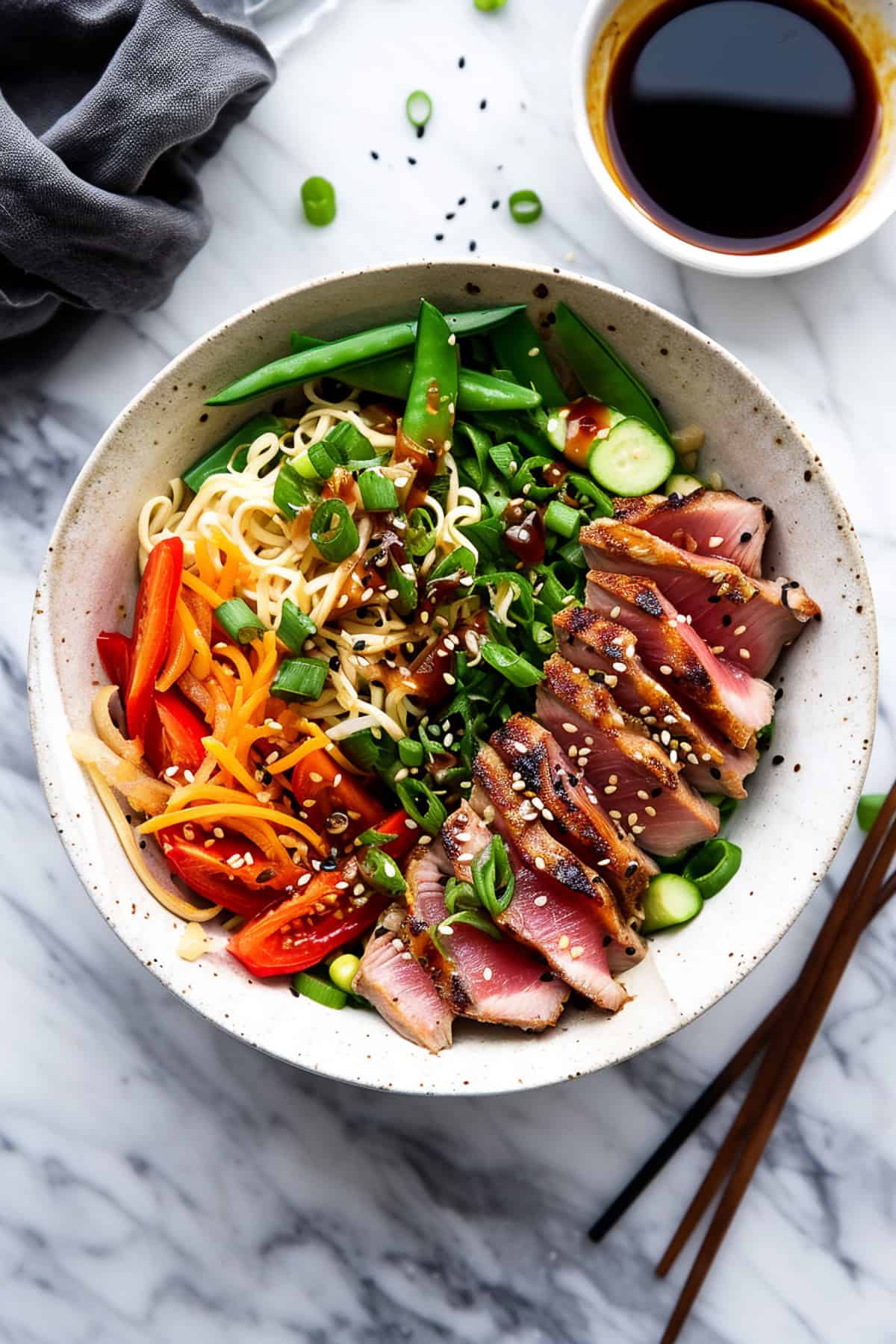 Seared Asian tuna noodle bowls with soy sauce.