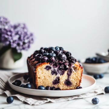 Soft and fluffy blueberry loaf on a white plate.