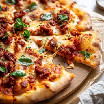 Chorizo pizza with cheese and basil.