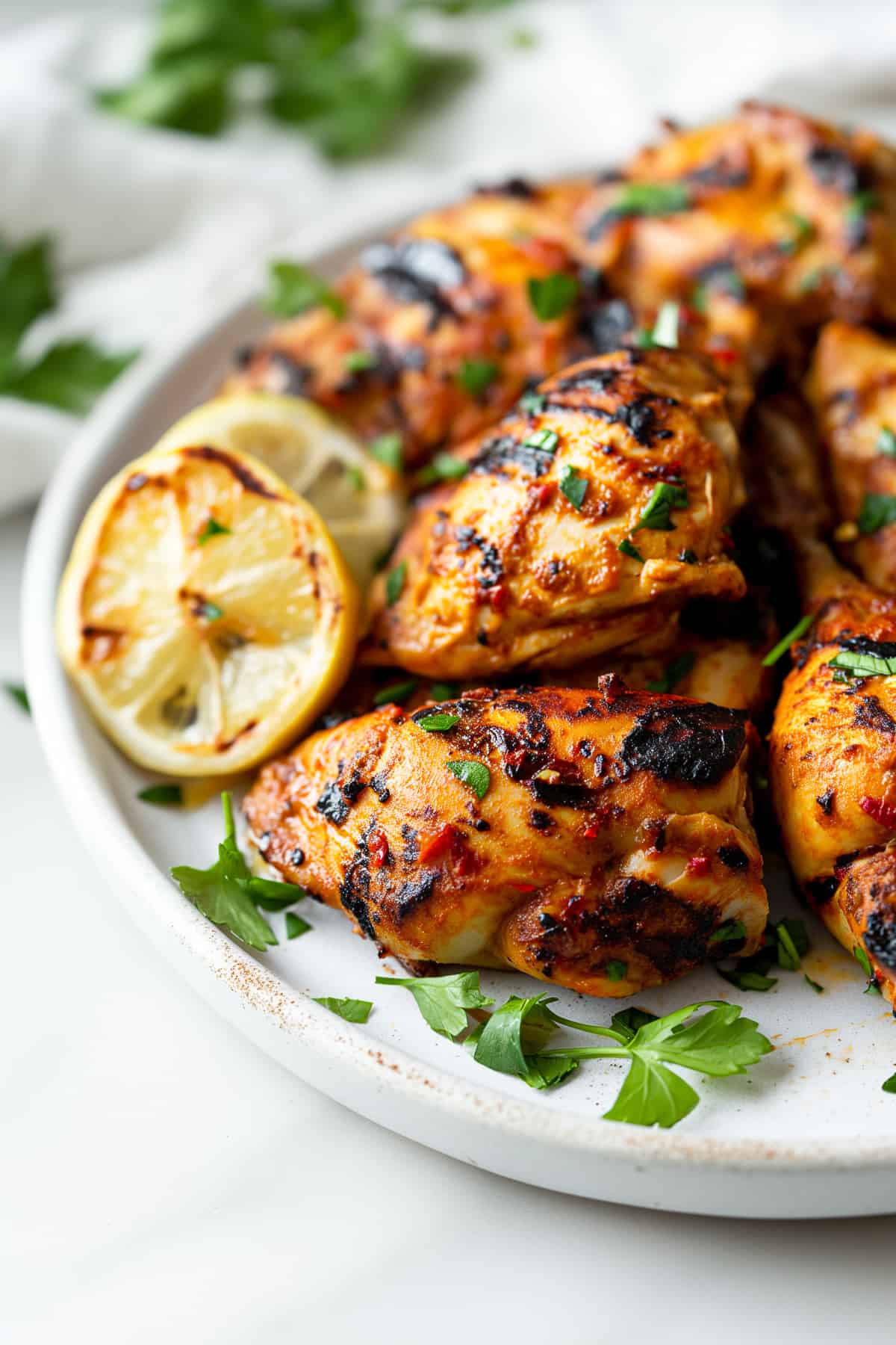 Grilled Moroccan chicken on a white plate.