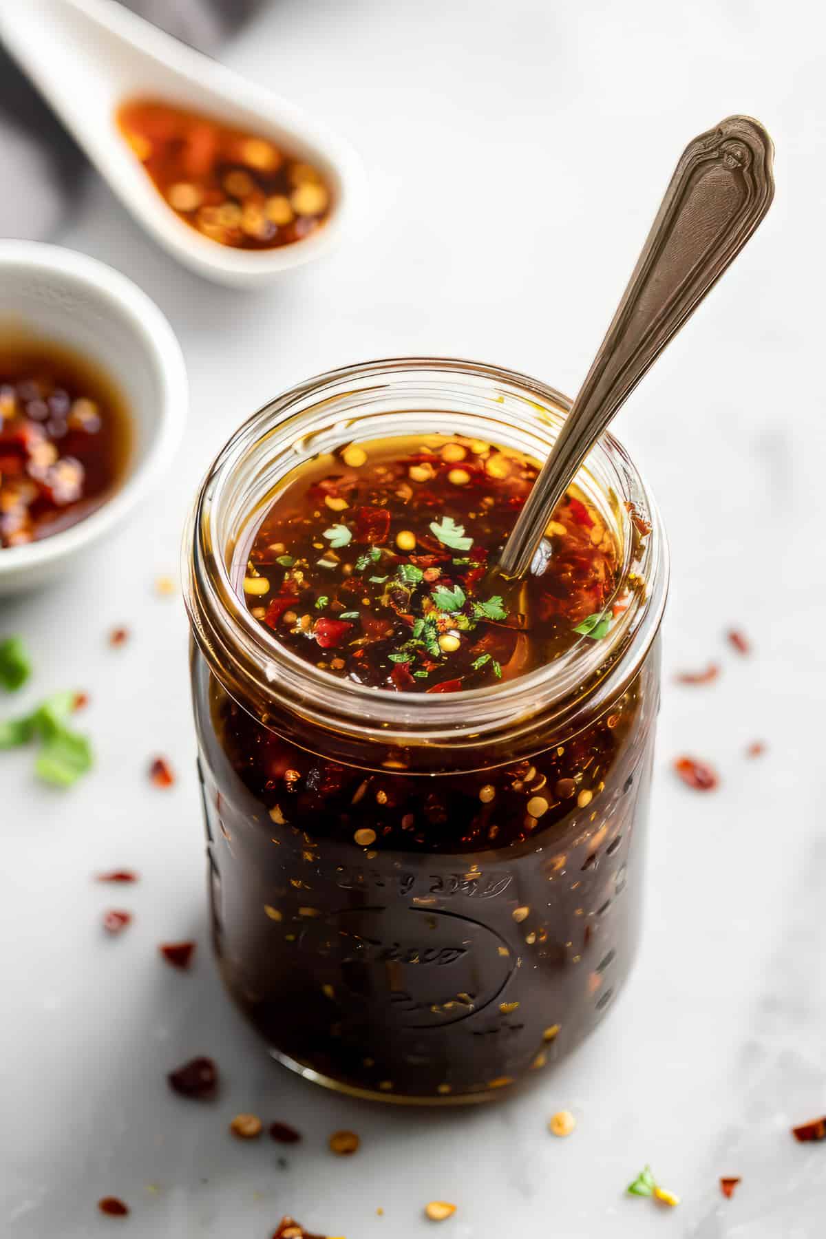 Homemade honey garlic sauce in a jar with a spoon.