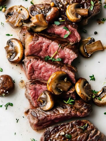 Cooked rib eye steak with mushrooms.