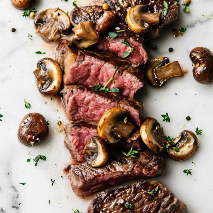 Cooked rib eye steak with mushrooms.