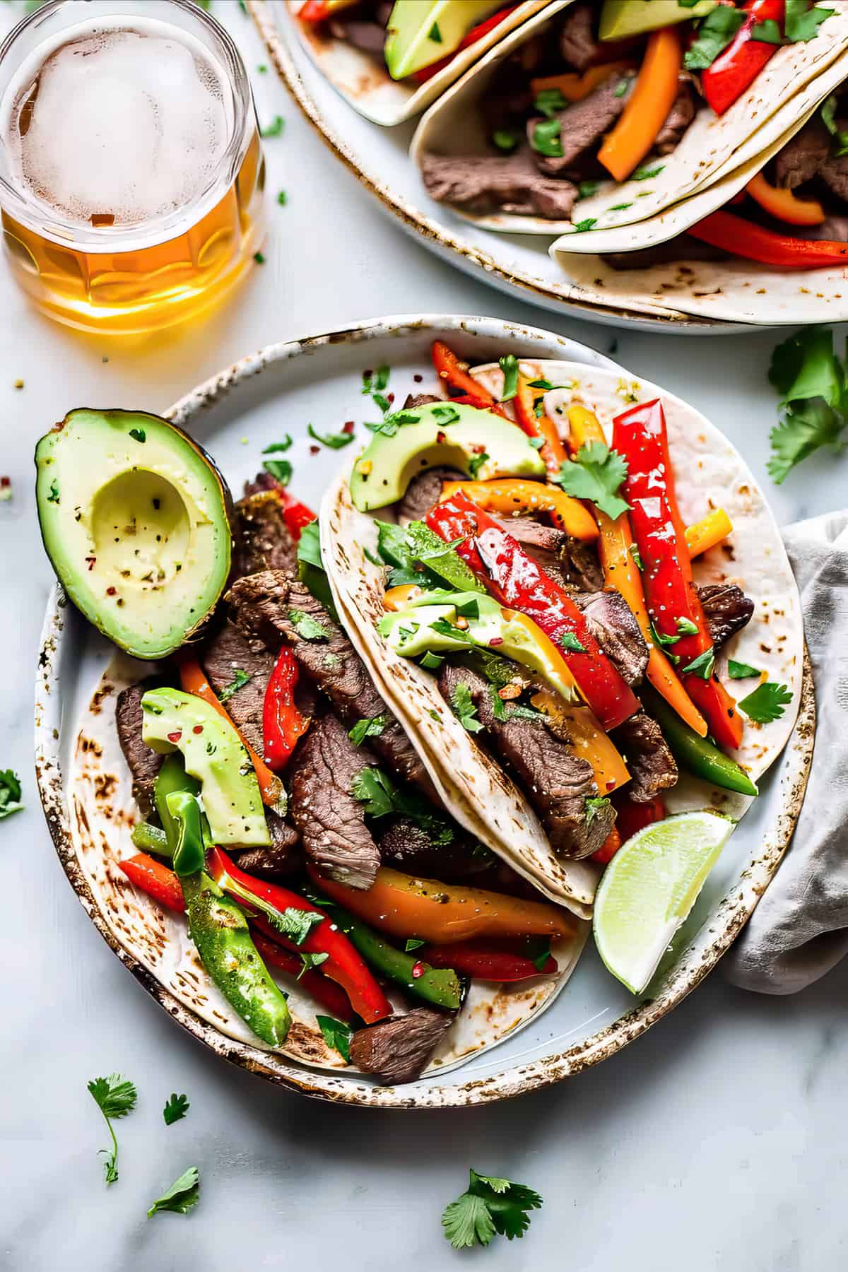 Marinated flank steak fajitas with peppers and avocado.