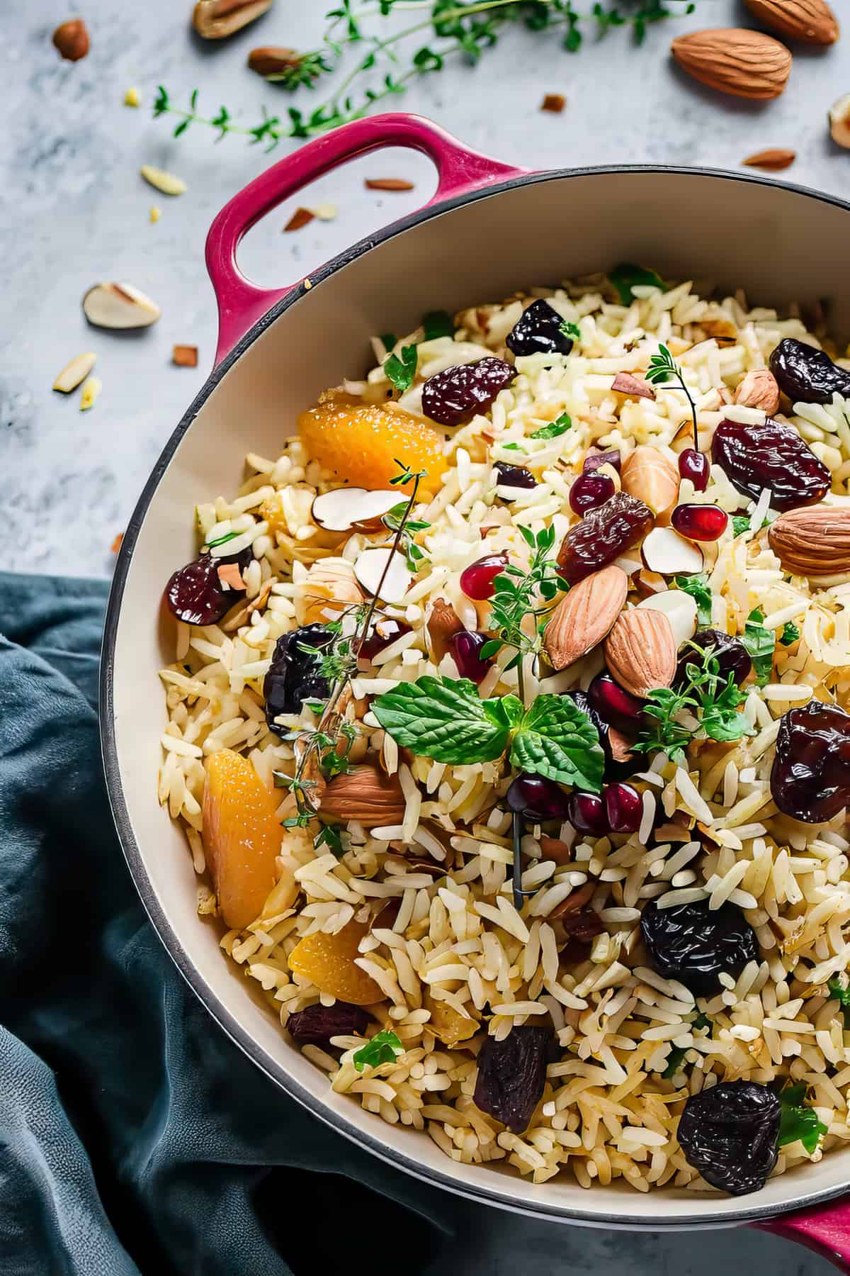 Moroccan rice pilaf in a pot with dried fruits, nuts and fresh herbs.