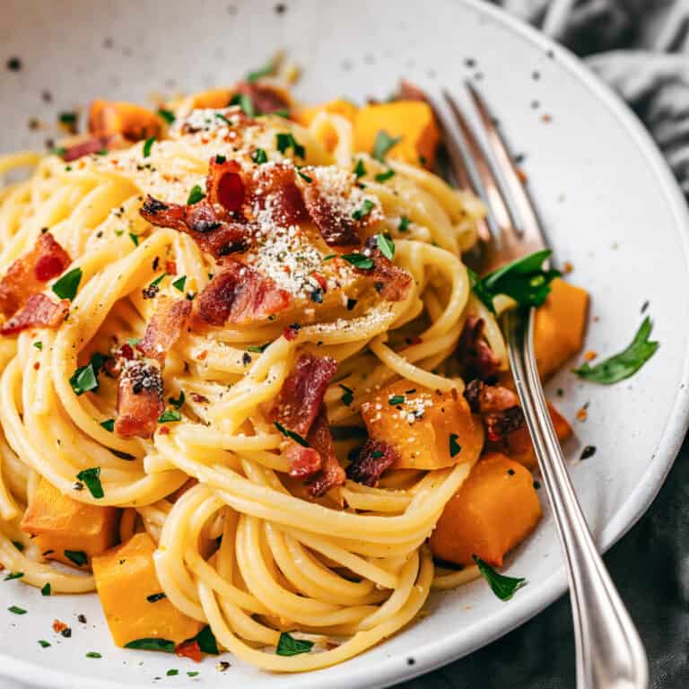 Pumpkin carbonara spaghetti with bacon and herbs.