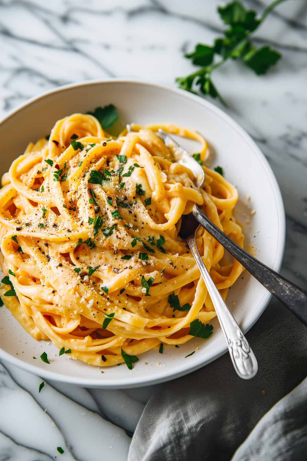 Creamy pumpkin alfredo with parmesan cheese in a white bowl.