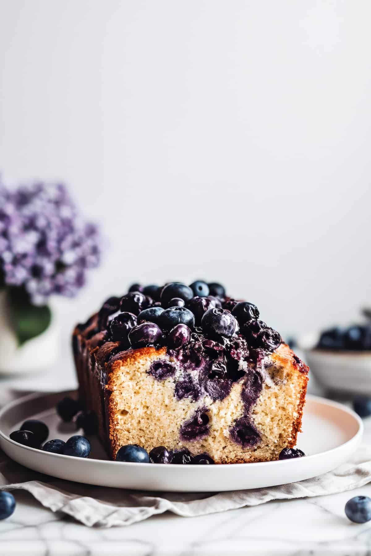 Soft and fluffy blueberry loaf on a white plate.