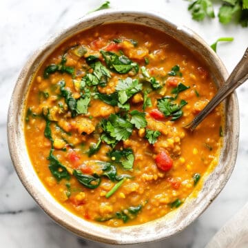 Red lentil curry (dhal) with spinach and tomatoes topped with cilantro.