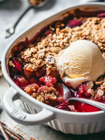 Fruit crisp with ice cream in a baking dish.