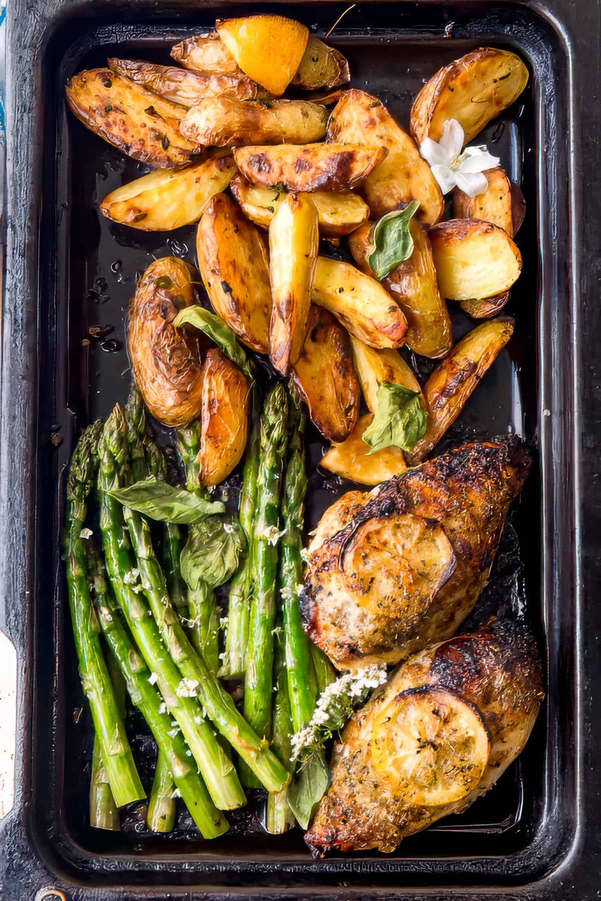Sheet pan chicken and potatoes with lemon and herbs.