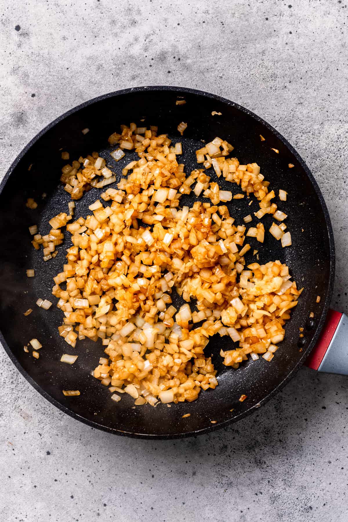 Sautéing onions in a pan for mushroom pork chops.