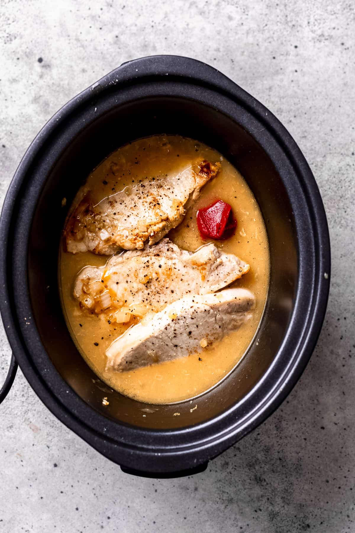 Slow cooker pork chops ingredients in the crock pot.